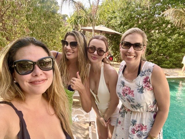 Four members smiling by the pool